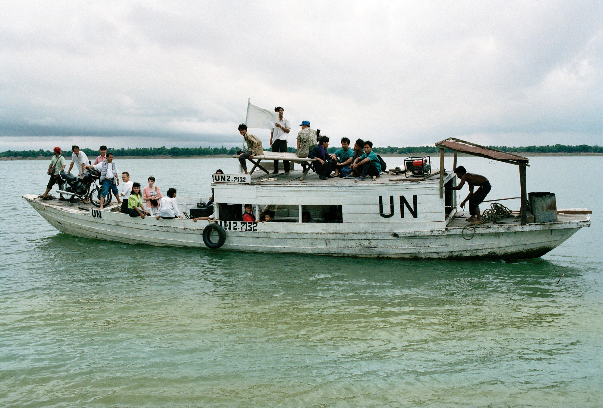 An UNTAC civic education team travels by boat to a Cambodian island to publicize voting procedures.
