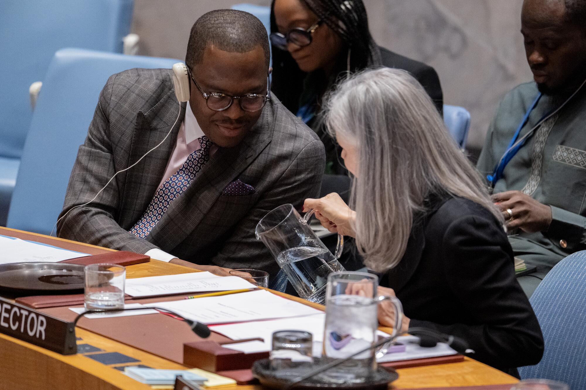 A view of Claudia Banz (right), Director of the Security Council Affairs Division of the Department of Political and Peacebuilding Affairs (DPPA), serving Michael Imran Kanu (left), Permanent Representative of Sierra Leone to the UN and President of the Security Council for the month of November, some water during the Security Council meeting on the situation in the Middle East (Syria).